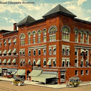 May include: Vintage postcard of the Olean House in Olean, N.Y., under Southern Tier Hotel Company direction. The multi-story brick building features arched windows, awnings, and a dark roof. Early automobiles and horse-drawn carriages are visible on the street.