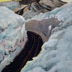May include: Vintage postcard featuring the Cog Wheel Road through Snow Pikes Peak, Colorado. The image shows a railway track winding through a snow-covered mountain pass. The sky is a mix of yellow and pink hues.
