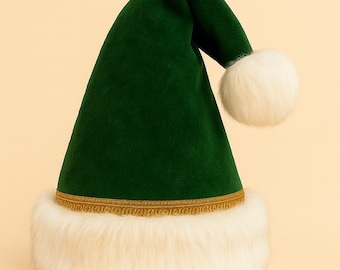 May include: A green velvet Santa hat with a white faux fur trim and a gold-colored band. The hat has a white pom-pom at the tip. The hat is a festive accessory for the holiday season.