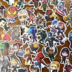 Puede incluir: Una colección de pegatinas de personajes de superhéroes coloridos con personajes como Spider-Man, Iron Man, Thor, Black Panther y Captain America. Las pegatinas están impresas en papel blanco y tienen un acabado brillante.