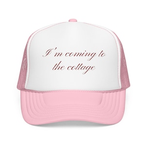 Peut inclure: Casquette de camionneur rose et blanche avec le texte "I'm coming to the cottage" en écriture cursive. La casquette a une visière rose et un dos en filet, avec un panneau avant blanc.