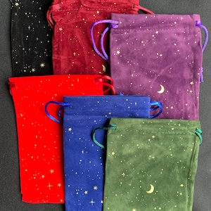 May include: Six velvet drawstring pouches with gold star and crescent moon patterns. The pouches are in black, burgundy, purple, red, blue, and green.