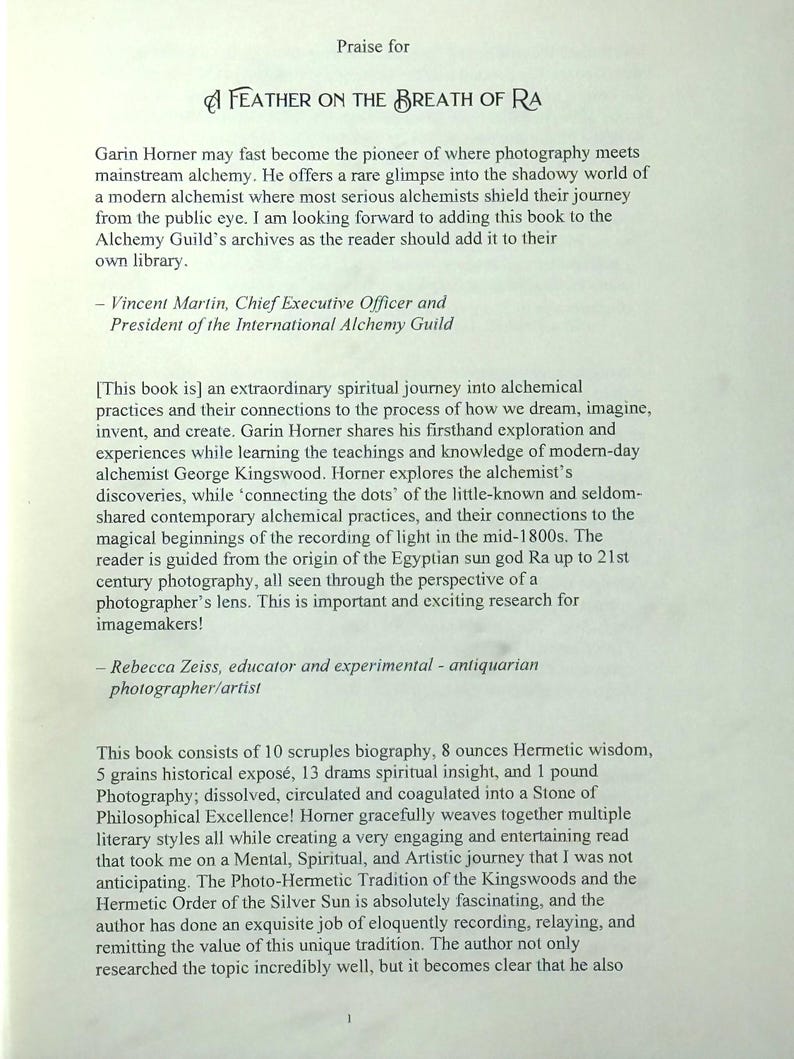 K&ouml;nnte beinhalten: Eine Buchseite mit dem Titel "A Feather on the Breath of Ra", die die Erforschung von Alchemie und Fotografie lobt. Der Text enth&auml;lt Zitate von Vincent Martin und Rebecca Zeiss sowie Details &uuml;ber den Inhalt des Buches. Gedruckt auf cremefarbenem Papier.