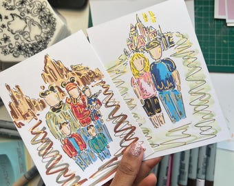 Può includere: Due biglietti di auguri disegnati a mano con illustrazioni colorate di persone e un castello. I biglietti sono tenuti in mano, con pennarelli e materiali artistici sullo sfondo. L'opera d'arte ha uno stile stravagante e fumettistico.