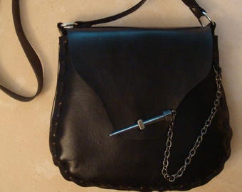 Peut inclure: Un sac à bandoulière en cuir noir avec une chaîne argentée et un accent en métal argenté. Le sac a une fermeture à rabat et un design cousu.