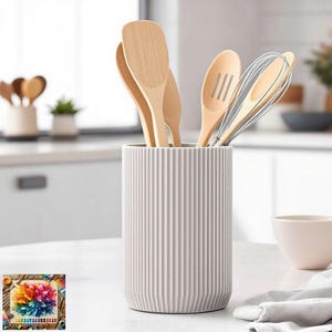 May include: A selection of wooden kitchen utensils, such as spatulas, slotted spoons, and a whisk, are arranged in a ribbed, off-white ceramic utensil holder. The holder is on a white countertop, suggesting a kitchen setting.