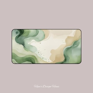 Könnte beinhalten: Rechteckige Schreibtischunterlage mit Aquarelldesign. Die Matte zeigt fließende abstrakte Formen in Grün- und Beigetönen mit einem schwarzen Rand. Das Design hat eine weiche, organische Ausstrahlung. Der Text "Hope's Design Haus" befindet sich unten.