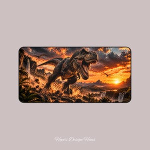 Puede incluir: Una alfombrilla de escritorio rectangular con una ilustración detallada de un Tyrannosaurus Rex rugiendo en un paisaje prehistórico al atardecer. La escena incluye montañas, cascadas y pterosaurios voladores bajo un cielo naranja.