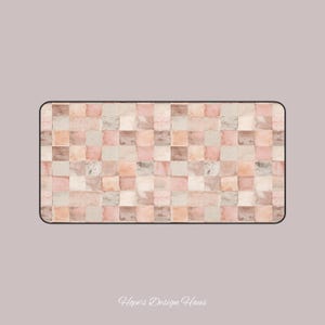 May include: Rectangular desk mat featuring a mosaic tile design in pink, beige, and brown hues. The mat has a black border and the text "Hope's Design Haus" in the bottom right corner.