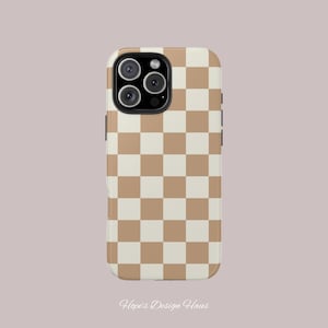 May include: A phone case with a tan and cream checkerboard pattern. The case has a glossy finish and a camera cutout for a multi-lens camera. The text "Hope's Design Haus" is at the bottom of the case.