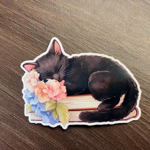 Gato negro duerme en libros pegatina, flores de primavera, vinilo impermeable, regalos para amantes de los libros, pegatinas de lectura, pegatinas de animales