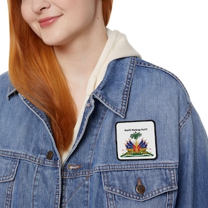 May include: A blue denim jacket with a white patch featuring the Haitian flag and the text "Haiti Sakap fet?"