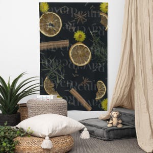 Puede incluir: Tapiz de pared negro con rodajas de naranja secas, palitos de canela, flores amarillas y texto. El tapiz rectangular está decorado con elementos naturales y está colgado en una pared.