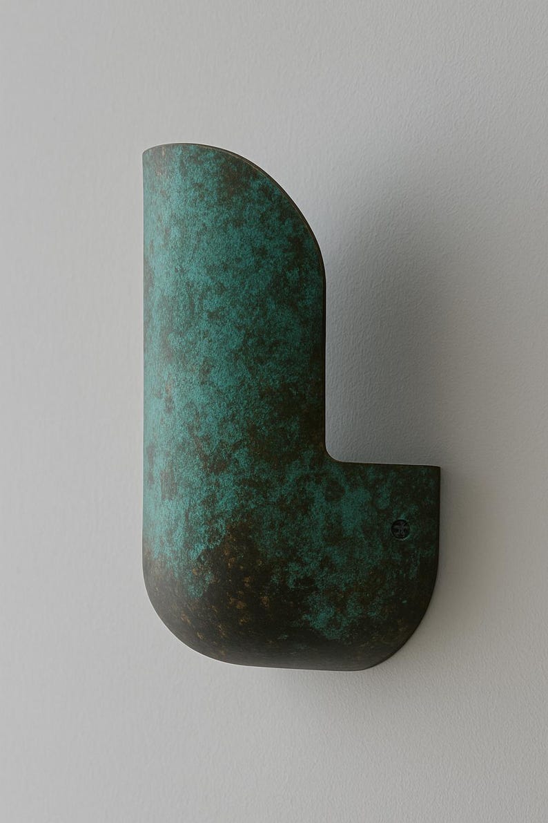 May include: A wall-mounted, curved, metal light fixture with a green patina finish.