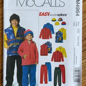 May include: A McCall's M4964 sewing pattern envelope for Polar Gear clothing. The front shows two children wearing fleece vests, jackets, pants, and hats. Illustrations display various color options for jackets, vests, pants, and hats in red, blue, and yellow.