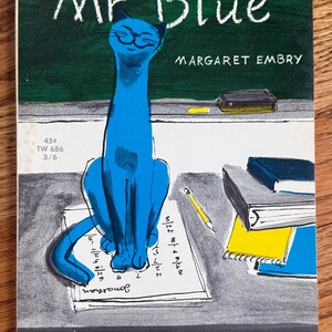 May include: A vintage book cover titled Mr Blue by Margaret Embry with pictures by Brinton Turkle. The illustration features a bright blue cat sitting on a piece of paper with handwritten numbers on a desk, next to a stack of books and a pencil.
