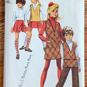 May include: Simplicity sewing pattern number 8481 for girls' clothing. The pattern includes three different outfits: a red and white short set, a plaid dress with a vest, and a plaid vest with brown pants. The pattern is for sizes 12 with a 30-inch bust.