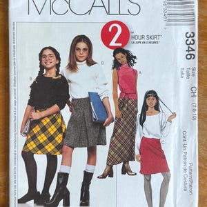 May include: A McCall's 3346 sewing pattern envelope for a 2 Hour Skirt in size CH (7-8-10). The front features illustrations of four different skirt styles, including a yellow plaid skirt, a grey tweed skirt, a long plaid skirt, and a solid red skirt.