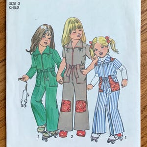 May include: Simplicity sewing pattern 7277 for a child's jumpsuit. The illustration shows three children wearing jumpsuits in green, tan, and blue striped fabric. The tan jumpsuit has red patterned knee patches. The pattern is size 3.