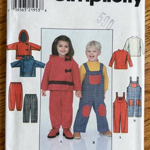 May include: Simplicity sewing pattern featuring children's clothing designs. The pattern includes illustrations of a red hooded jacket and pants, a blue jacket, and overalls. The pattern also shows a girl and boy wearing the clothing.
