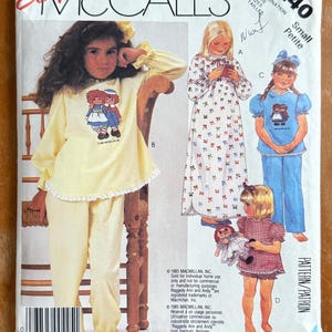 May include: McCall's sewing pattern 2240 for children's sleepwear. The pattern features illustrations of girls in pajamas and nightgowns. The cover shows a yellow pajama set with a Raggedy Ann and Andy graphic.