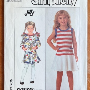 May include: Simplicity Jiffy pattern for girls' dresses. The pattern features two dress designs, one with a colorful print and the other with red and white stripes. The pattern includes the text "OVERLOCK/SERGER".