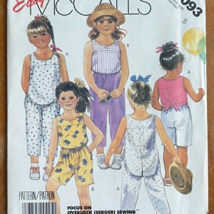 May include: A vintage McCall's sewing pattern for children's clothing. The pattern features illustrations of children wearing various outfits, including shorts, pants, and tops. The pattern number is 3093, and the size is 5.
