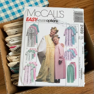 May include: A McCall's sewing pattern for a child's robe and nightgown. The pattern includes instructions for making a robe with a sash and a nightgown with long sleeves and a ruffled collar. The pattern is for sizes X-Small to Small.
