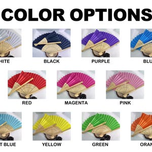 May include: A variety of colorful hand fans are displayed, each with a bamboo handle and pleated paper. The available colors include white, black, purple, blue, red, magenta, pink, light blue, yellow, green, and orange. The text "COLOR OPTIONS" is at the top.