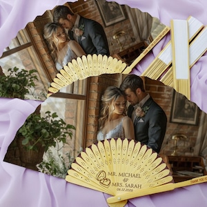 Könnte beinhalten: Holz-Hochzeitsfächer mit einem Foto eines Paares. Auf den Fächern steht der Text "Mr. Michael Mrs. Sarah 06.12.2026" und "Thank you for celebrating with us!". Die Fächer haben ein dekoratives Design.
