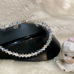 Puede incluir: Un delicado brazalete de plata con un dije de corazón y cuentas de cristal transparente.