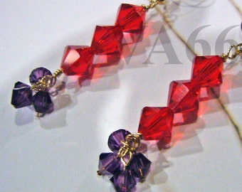 May include: A pair of dangle earrings with red and purple crystal beads. The red beads are faceted and arranged in a staggered pattern. The purple beads are clustered at the bottom of the earrings.