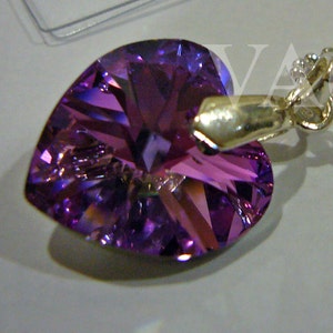 Pode incluir: Um pingente de cristal em forma de coração roxo em uma corrente de prata.