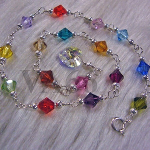 May include: A silver anklet with a rainbow of faceted crystals in red, orange, yellow, green, blue, purple, and pink. The crystals are linked by a fine silver chain with small silver beads. A heart-shaped crystal is also included.