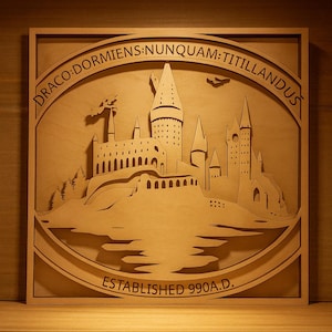 Könnte beinhalten: Wandkunst aus Holz mit einem lasergeschnittenen Schlossmotiv, inklusive der Texte "DRACO DORMIENS NUNQUAM TITILLANDUS" und "ESTABLISHED 990 A.D." Das Kunstwerk ist gerahmt und hat eine natürliche Holzoberfläche.