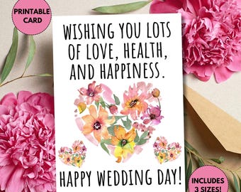 Op de afbeelding: Een witte trouwkaart met de tekst "WISHING YOU LOTS OF LOVE, HEALTH, AND HAPPINESS. HAPPY WEDDING DAY!" en een bloemenhartontwerp. De kaart bevat drie formaten en is een printbare kaart.