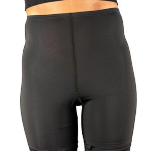 Op de afbeelding: Zwarte, hoge taille shorts met een gladde, matte afwerking. De shorts hebben een ritsdetail aan de zijkanten en een naad in het midden aan de voorkant.