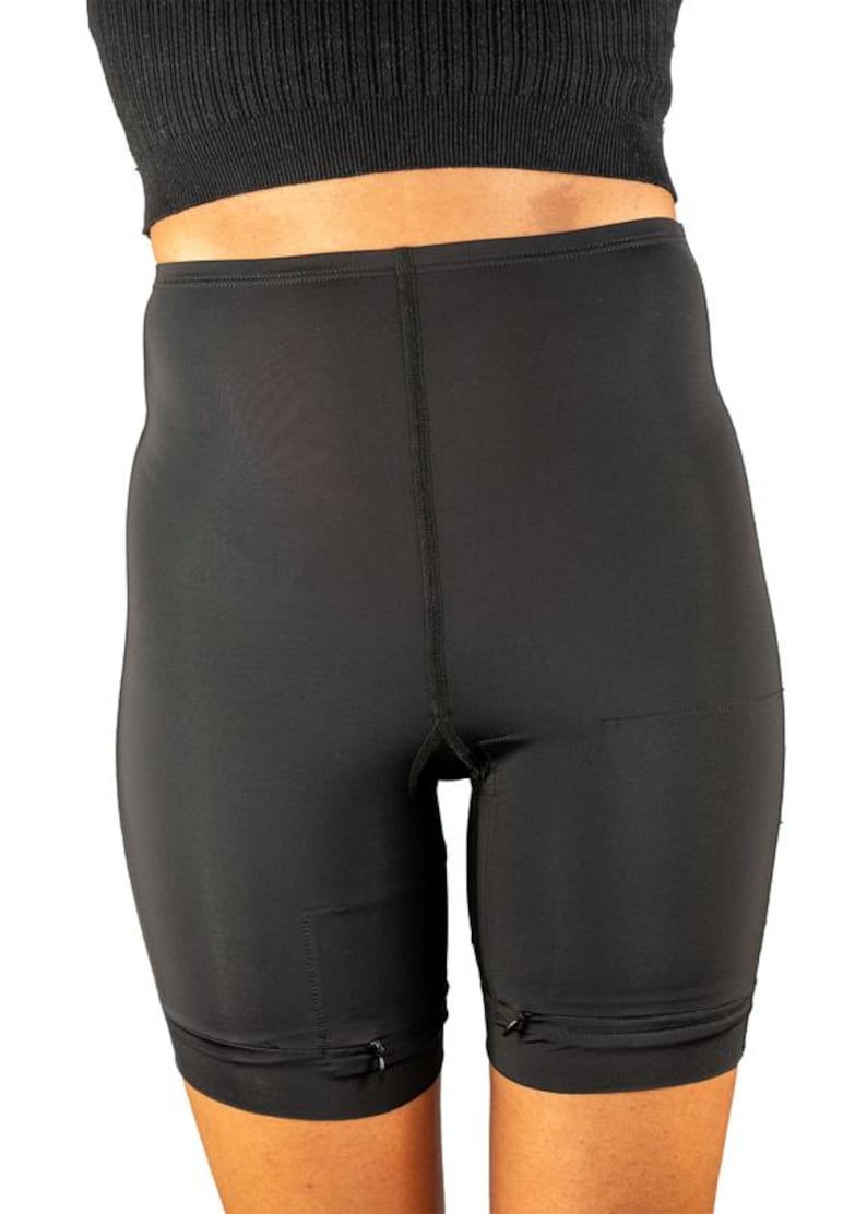 Op de afbeelding: Zwarte, hoge taille shorts met een gladde, matte afwerking. De shorts hebben een ritsdetail aan de zijkanten en een naad in het midden aan de voorkant.