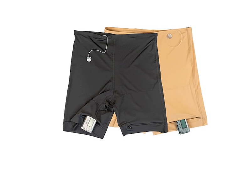 Op de afbeelding: Twee paar sport shorts, een zwarte en een bruine, met een klein elektronisch apparaat in de zak van elk.
