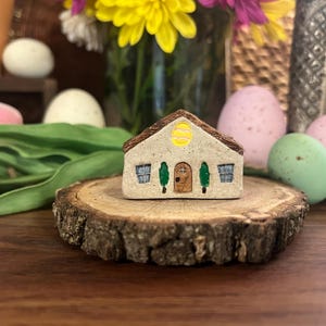 May include: A handmade wooden sign with the text "Welcome to our home" in a handwritten style. The sign is painted white with black lettering and features a small, decorative heart. It is designed for indoor or outdoor use.