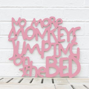 May include: Pink wooden sign with the text "No more monkeys jumping on the bed".