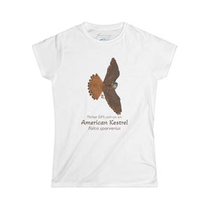 May include: White women's t-shirt with a brown and white illustration of an American Kestrel in flight. The text "Flicker GPS unit on an American Kestrel! Falco sparverius" is printed below the illustration.