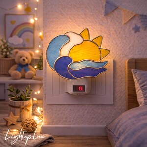 May include: A stained glass plug-in night light featuring a yellow sun and blue waves, mounted on a white wall outlet. The light has a small rectangular base with a red power switch displaying the number zero in a digital font style.