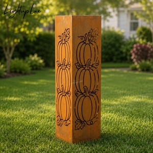Könnte beinhalten: Eine hohe, rechteckige Gartenstele aus rostfarbenem Metall mit lasergeschnittenen Motiven von gestapelten Kürbissen und Blättern auf der Vorder- und Seitenfläche. Die Struktur weist eine verwitterte, oxidierte Oberfläche auf.