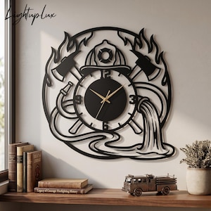 Puede incluir: Reloj de pared de metal negro con temática de bombero. El reloj presenta un diseño circular con un casco de bombero, hachas y una manguera de agua. Las manecillas del reloj son doradas. El reloj está montado en una pared clara.