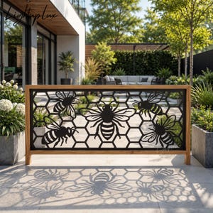 May include: A rectangular metal privacy screen featuring a black laser-cut honeycomb pattern with four bee silhouettes. The screen is framed in natural wood and stands on a light-colored patio, casting a detailed shadow of the bee and honeycomb design.