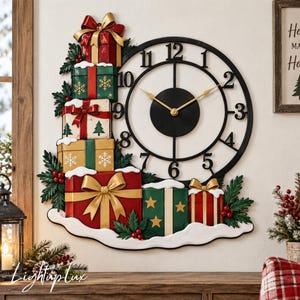 Könnte beinhalten: Eine Wanduhr mit schwarzem, kreisförmigem Rahmen sowie goldenen Zeigern und Ziffern. Ein Stapel bunter Geschenkboxen in Rot, Grün und Gold mit Schleifen, Stechpalmenblättern und weißen Schneeakzenten ist links und unten an der Uhr befestigt.
