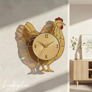May include: A stained glass wall clock shaped like a chicken with amber-colored glass panels, a red comb, and a circular gold-toned clock face featuring black numerals 3, 6, 9, and 12 with matching gold-toned hour and minute hands.