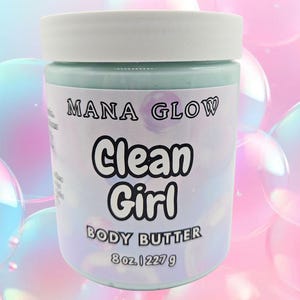 May include: A jar of "Mana Glow Clean Girl Body Butter" with a white lid. The jar is filled with a light blue substance and has text on the label. The label also indicates the product contains 8 oz | 227 g.