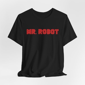 May include: Black t-shirt with the red text "MR. ROBOT" across the chest. The text has a layered effect, giving it a three-dimensional appearance. The shirt is made of a soft material.